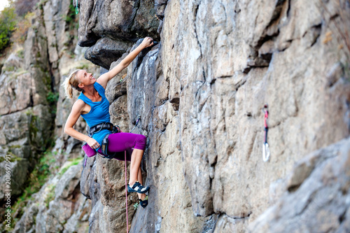 A woman climbs the rock.