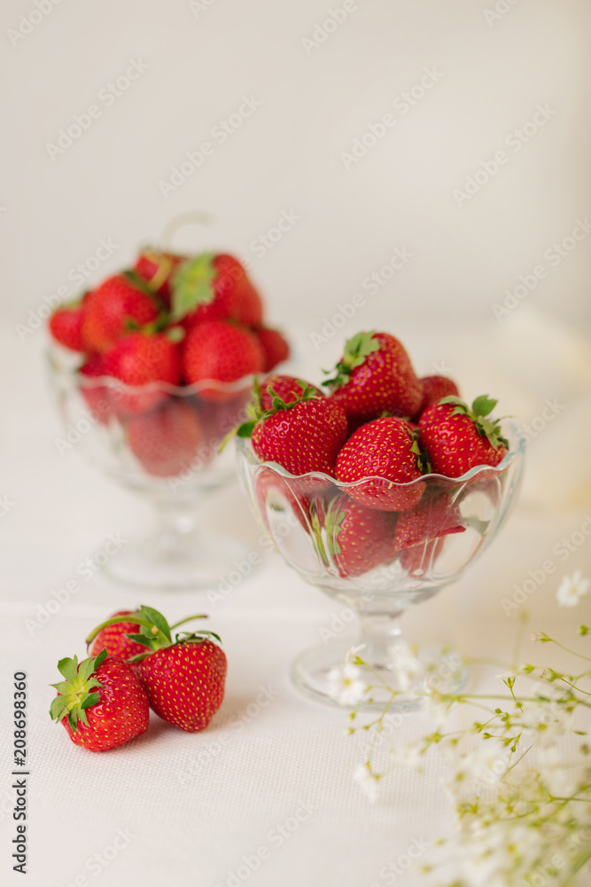 Strawberries in a jelly glass on a white background. Strawberries in a jelly glass on a white background.
