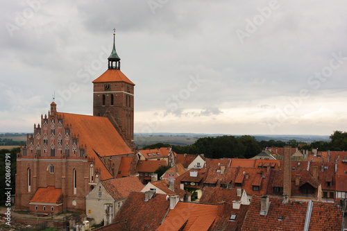 tiled roofs of an old church and houses on a cloudy day