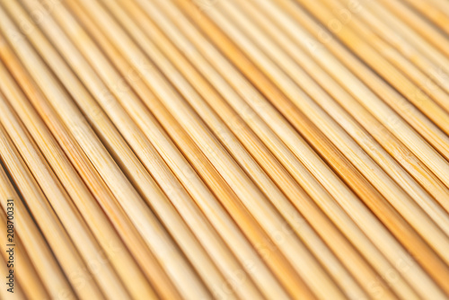 background of parallel round wooden sticks closeup