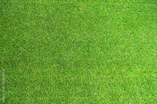 Artificial green grass. Texture it's look like real grass very similiar. Selective focus and close up.