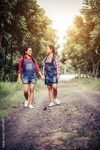 Two girls walking along a forest road