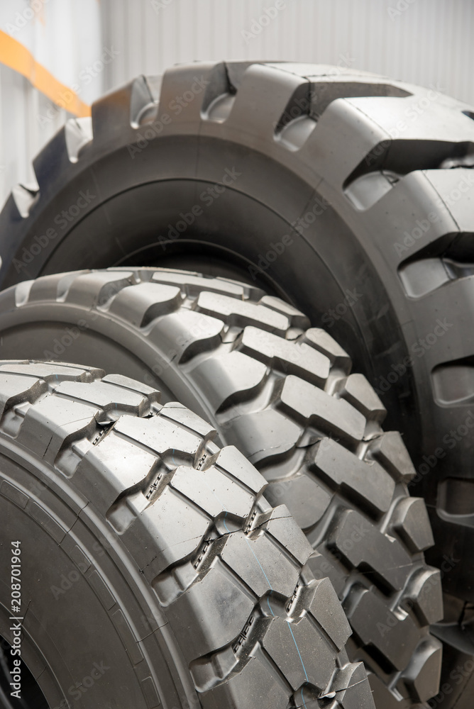 Several black rubber tires on sale with different tread pattern and different sizes for trucks and cars