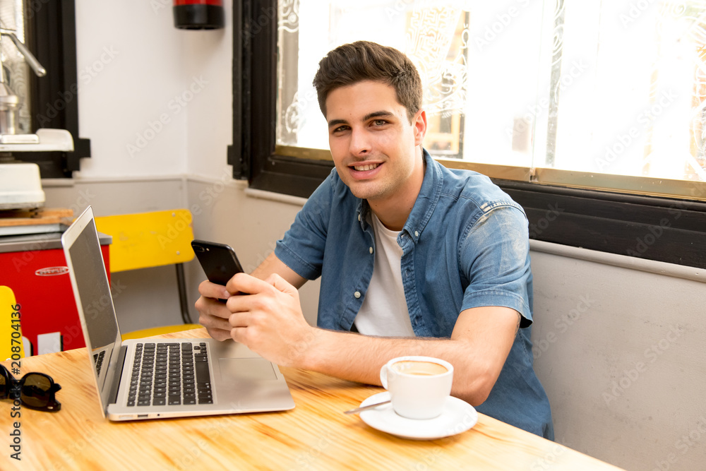 young student using his smart phone to read text while having a coffee young student using his smart phone to read text while having a coffee