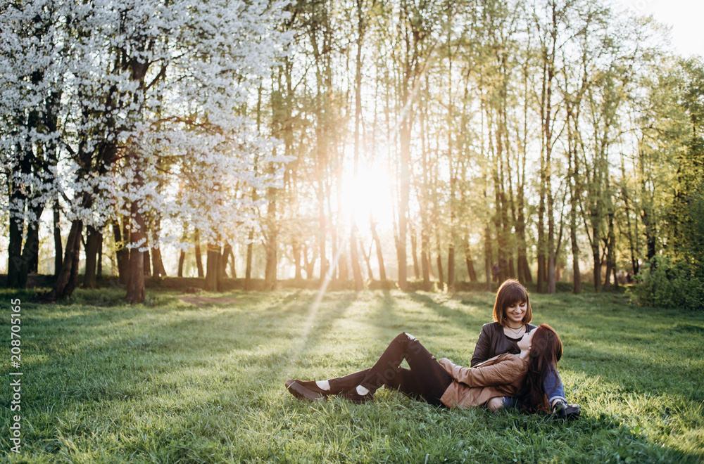 The beautiful sisters sitting on the grass The beautiful sisters sitting on the grass