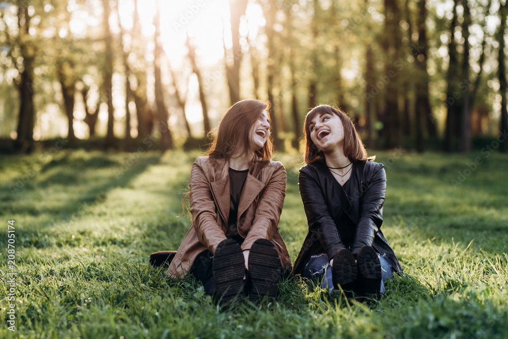 The beautiful sisters sitting on the grass