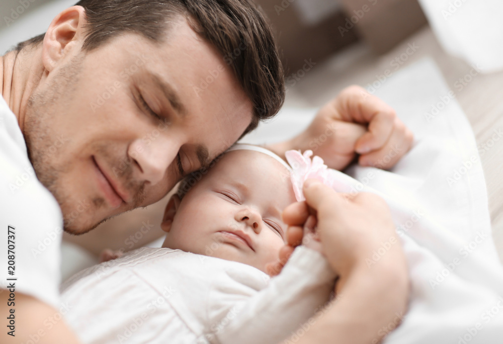 Young father and his baby on bed at home Young father and his baby on bed at home