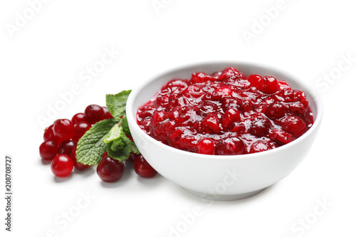 Bowl with tasty cranberry sauce on white background photo