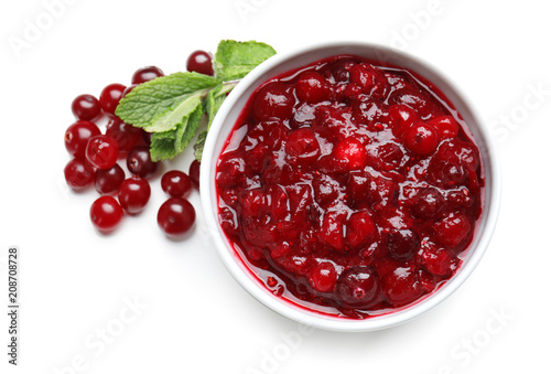 Bowl with tasty cranberry sauce on white background, top view photo