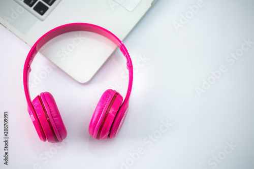 Pink headphones on laptop.