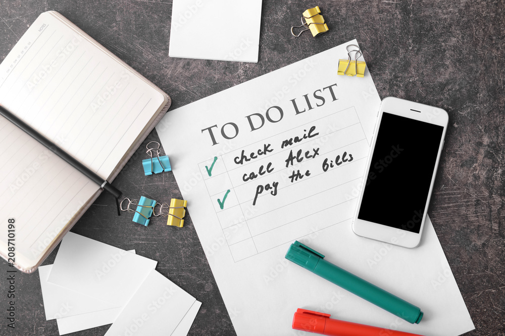 To-do list with phone and stationery on grey background To-do list with phone and stationery on grey background