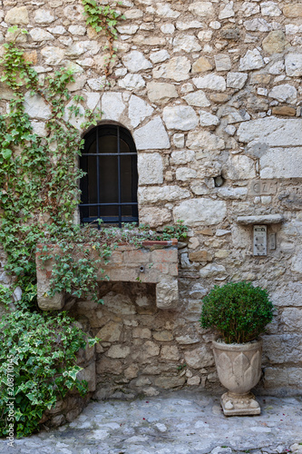 Window and ivy on stone wall in Eze, France