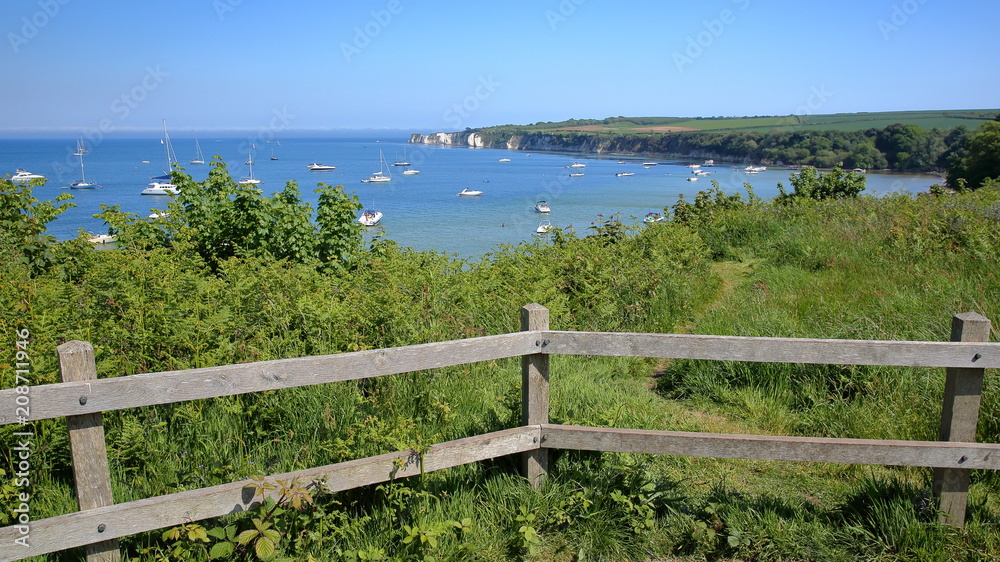 Studland bay with mooring boats and Old Harry Rocks in the background near Swanage, Isle of Purbeck, Dorset, UK