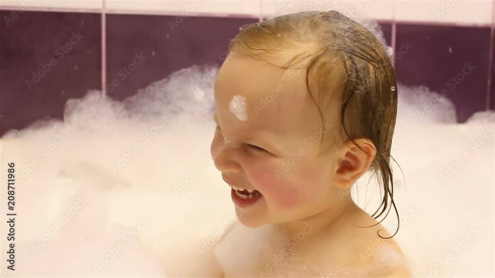 little happy girl bathes in the bathroom with foam. He plays with foam. little happy girl bathes in the bathroom with foam. He plays with foam.