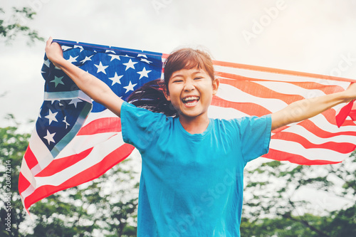 Happy kid little child running with American flag USA celebrate 4th of July photo