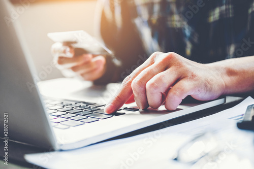 Man's hands typing laptop keyboard and holding credit card online shopping concept photo