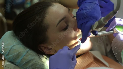 Young woman in dental clinic. Teeth cleaning. photo