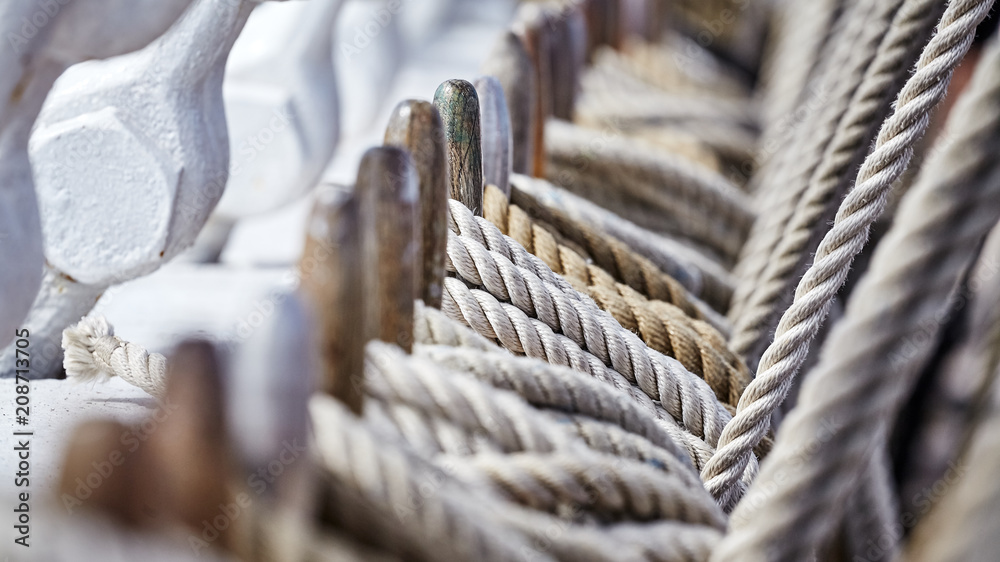 Old sailing ship rigging with belaying pins and ropes, shallow depth of field. Old sailing ship rigging with belaying pins and ropes, shallow depth of field.