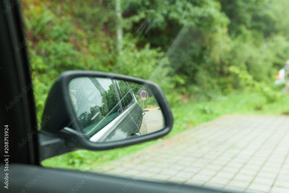 Landscape in the sideview mirror of a car , on road countryside.