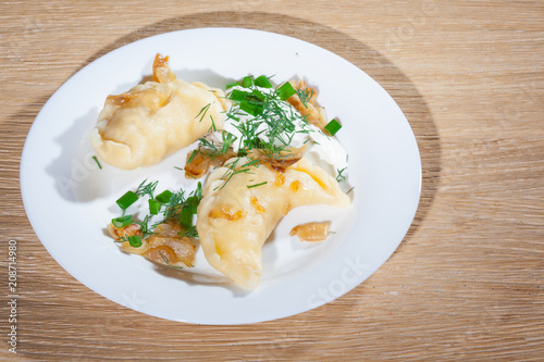 Ukrainian vareniki served on the Faror plate with onions, sour cream and dill