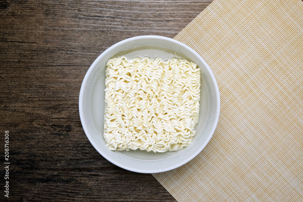 Top view of instant noodle in the glass bowl on the wooden table. Top view of instant noodle in the glass bowl on the wooden table.