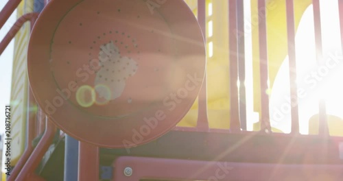 Toddler boy listening to red speaker in playstructure runs away - slow motion photo