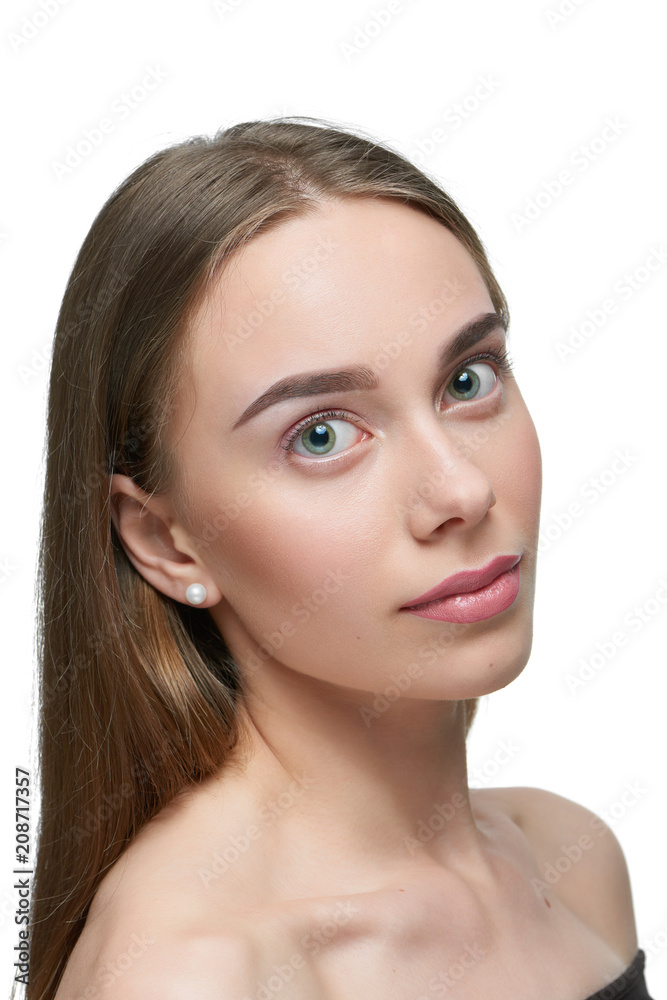 Studio portrait of a girl with light day make up looking at camera. model having beatiful face with nice straight eyebrows, plump lips, big eyes. Dark brown hair, opened shoulders. White background. Studio portrait of a girl with light day make up looking at camera. model having beatiful face with nice straight eyebrows, plump lips, big eyes. Dark brown hair, opened shoulders. White background.