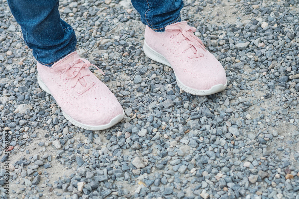 Closeup woman foot with pink shoe stand alone on floor textured background