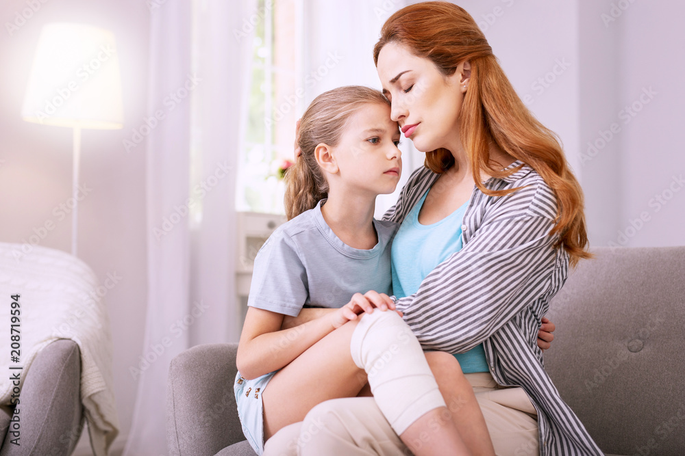 Family relationships. Pleasant red haired woman hugging her child while expressing her love Family relationships. Pleasant red haired woman hugging her child while expressing her love