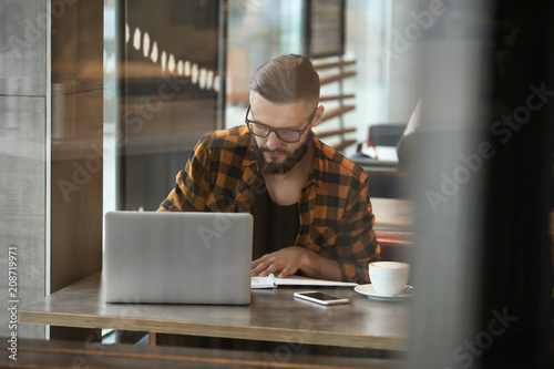 Young freelancer with lapto...