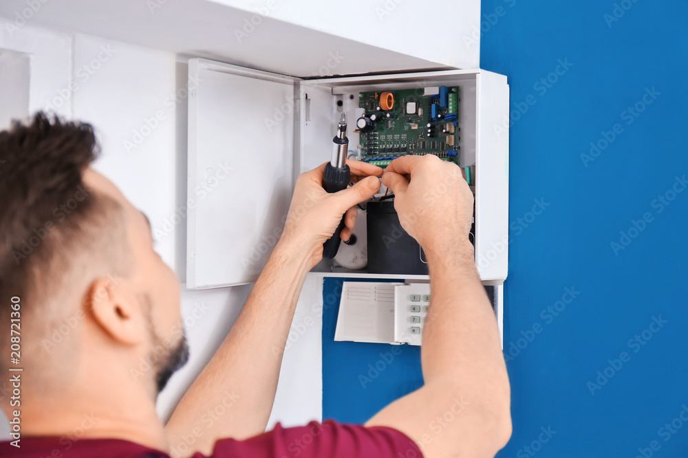 Electrician installing alarm system Electrician installing alarm system