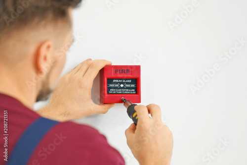Foto Electrician installing fire alarm system