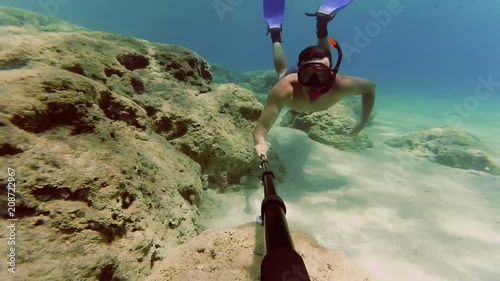 Young man dives to watch statue at the bottom of the sea