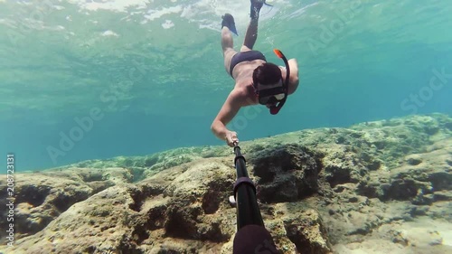 Young man dives to watch statue at the bottom of the sea