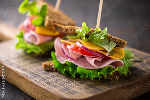 breakfast sandwich with salad, ham, cheese and tomato