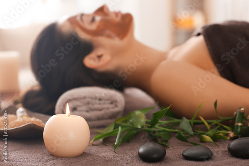 Spa accessories and relaxed young woman on background