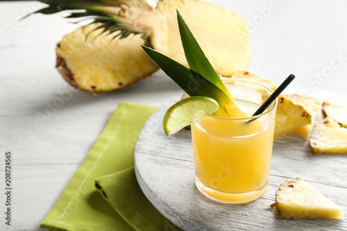 Glass of pineapple juice on wooden tray