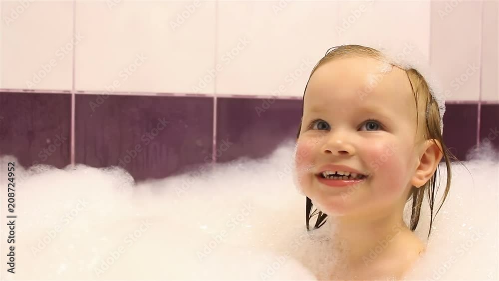 little happy girl bathes in the bathroom with foam. He plays with foam. little happy girl bathes in the bathroom with foam. He plays with foam.