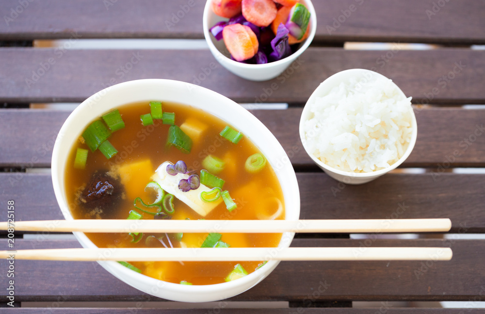 Traditional vegan miso soup with silken tofu, shiitake, dashi and scallion served with white rice and pickled vegetables Traditional vegan miso soup with silken tofu, shiitake, dashi and scallion served with white rice and pickled vegetables
