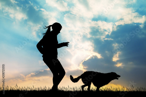 Fototapeta Naklejka Na Ścianę i Meble -  girl runs with dog at sunset