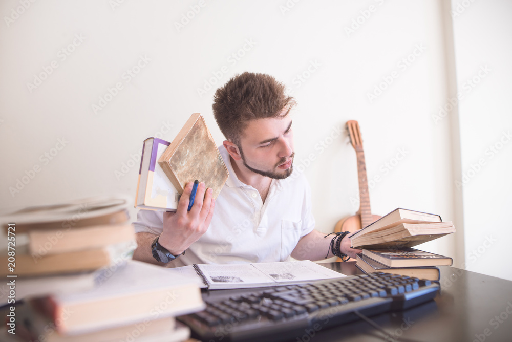 Student sitting at home at a computer desk and studying. A student with books in motion makes a homework assignment. Self-education at home. Teaching at home Student sitting at home at a computer desk and studying. A student with books in motion makes a homework assignment. Self-education at home. Teaching at home