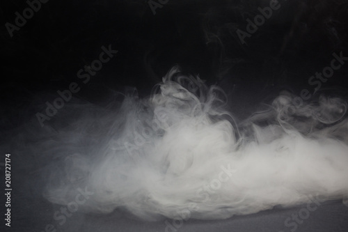 Cloud of white smoke on a black background closeup