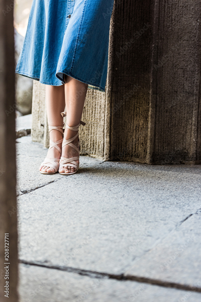 cropped shot of woman in denim skirt and stylish shoes on street cropped shot of woman in denim skirt and stylish shoes on street