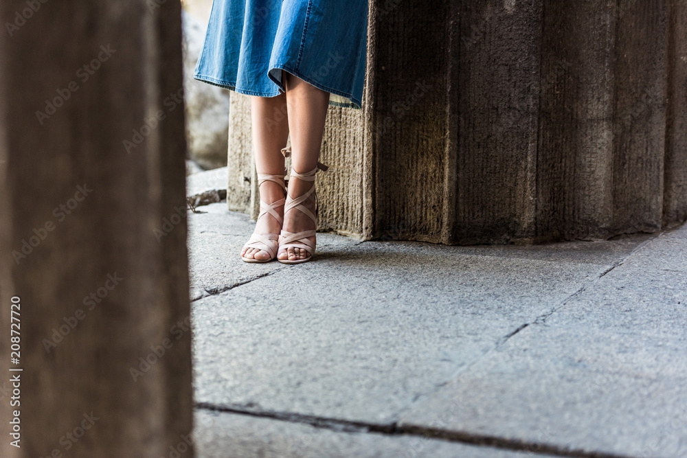 cropped shot of woman in denim skirt and shoes standing on street cropped shot of woman in denim skirt and shoes standing on street