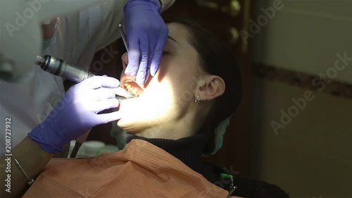 Young woman in dental clinic. Teeth cleaning. photo