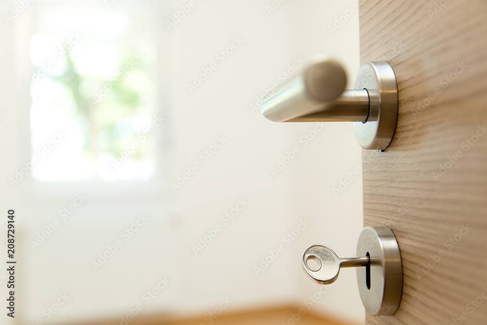 New apartment - House key in the door to modern living room New apartment - House key in the door to modern living room