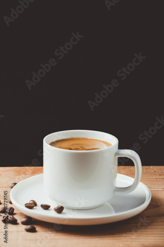 Espresso coffee cup on wooden table and dark background