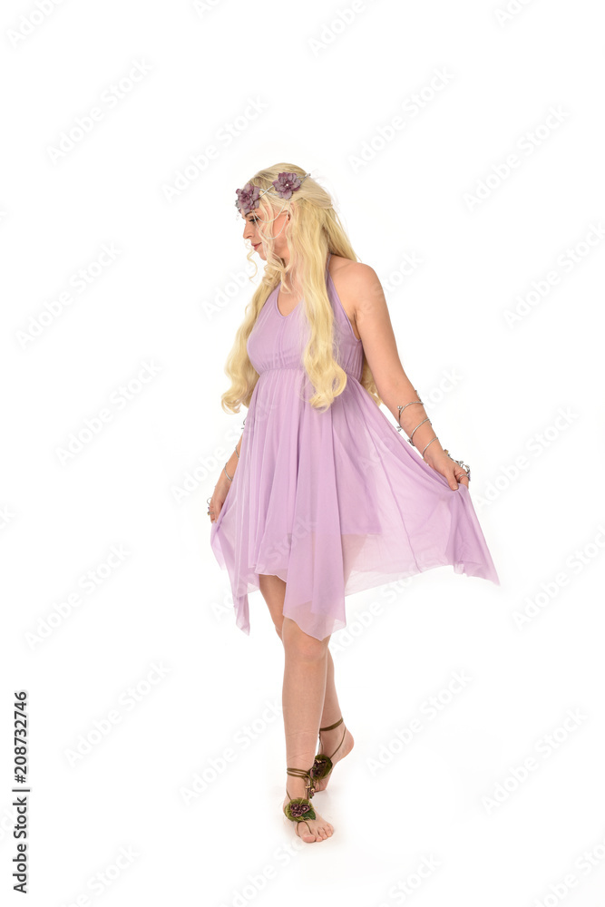 full length portrait of pretty blonde girl wearing purple fairy dress. standing pose, isolated on white studio background.