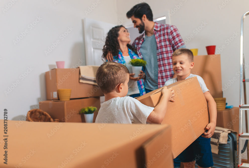 Happy young family moving into their new home. They carrying boxes into the apartment. Happy young family moving into their new home. They carrying boxes into the apartment.