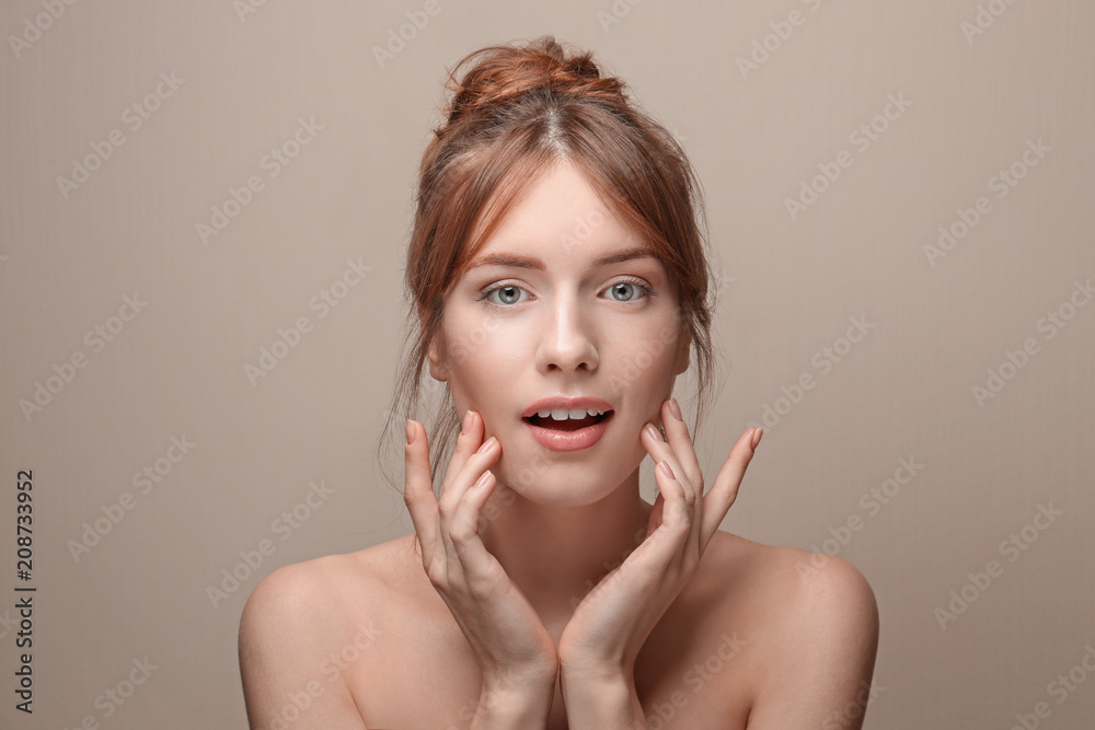 Beautiful young woman with silky skin on grey background Beautiful young woman with silky skin on grey background
